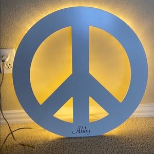 White peace sign that lights up when plugged in.